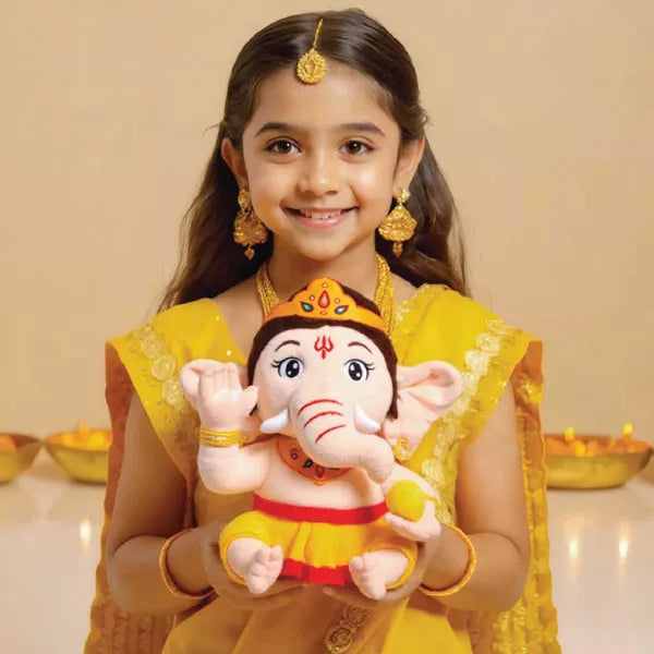 Young girl in traditional attire holding a mantra chanting plush toy of Lord Ganesha against a beige background.