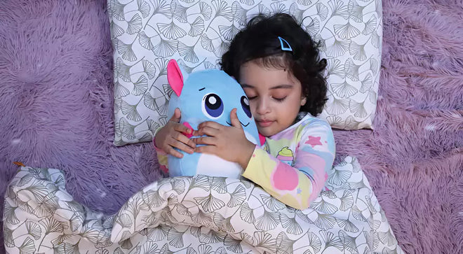 Child holding a blue plush toy on a patterned pillow with a purple textured background