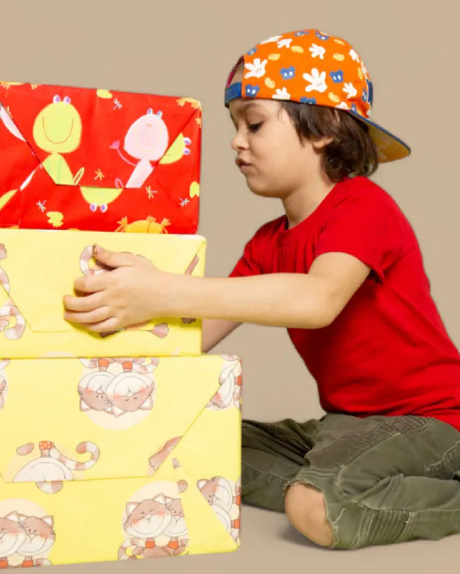 Child sitting with colorful aurbo bundle on a beige background